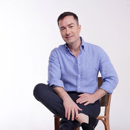 Luis César Bigonha sentado, em retrato informal
